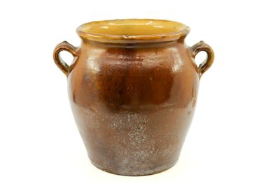 a brown vase with handles sitting on a white surface