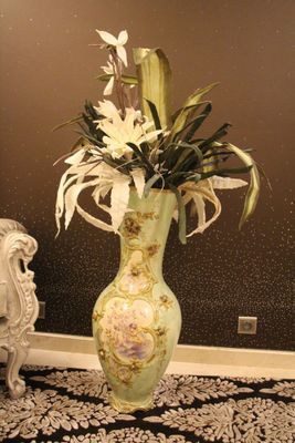 un vase contenant des fleurs blanches, posé sur un tapis noir et blanc