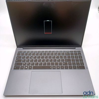 un ordinateur portable ouvert posé sur une table blanche