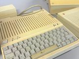 three old computers sitting on a table next to each other