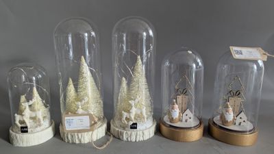 six glass cloches with snowmen and christmas trees in them