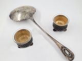 a spoon and two cups of coffee on the table