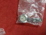 a plastic bag with a watch on it on a red surface