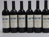 six bouteilles de vin sont alignées sur une table