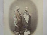 an old picture of two men in traditional clothing standing next to each other