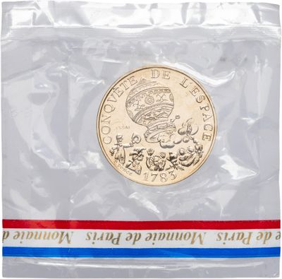 un gros plan d'une pièce de monnaie dans un sachet en plastique sur fond blanc