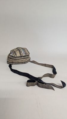 a hat that is laying on the ground with a ribbon