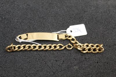 a close up of a gold chain bracelet with a tag on it