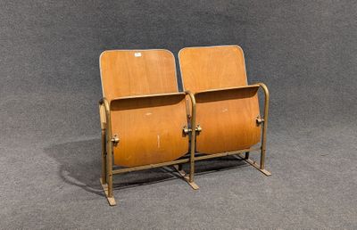 two wooden chairs sitting next to each other on a gray surface