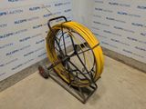 a yellow hose sitting on a cart in a room