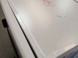a white refrigerator sitting on top of a pallet in a warehouse