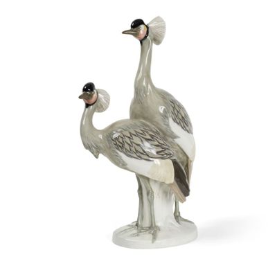 une paire d'oiseaux en porcelaine grise et blanche posés sur une surface blanche