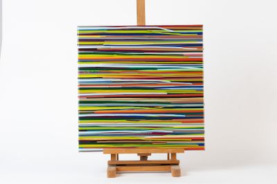 tableau aux couleurs vives posé sur un chevalet, sur fond blanc