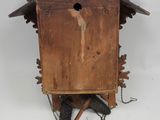 a wooden cuckoo clock hanging on the wall