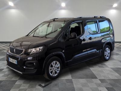 La camionnette noire est garée sur un sol en damier dans un garage.