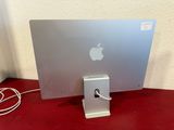 an apple computer sitting on top of a red table next to a white wall