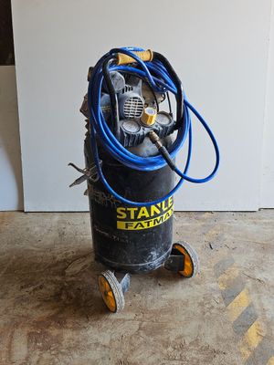un petit compresseur d'air posé par terre dans la pièce