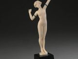 une statue représentant une femme tenant une batte de baseball, posée sur un socle noir
