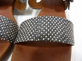 pair of black and white polka dot sandals on a white surface