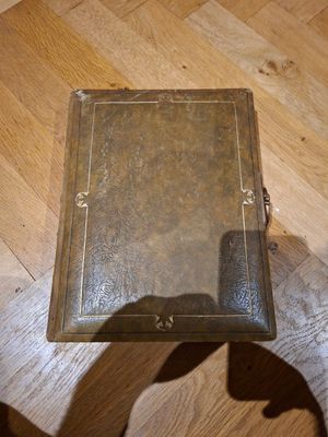 l'ombre d'une personne tenant un livre sur un plancher en bois