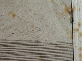 a dirty wall with rust on it in a room
