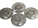 four metal plates with tags on them sitting on a white surface