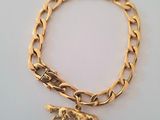 gold plated bracelet with a dog charm on it