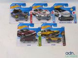 cinq petites voitures Hot Wheels exposées sur une table