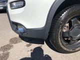 a shadow of a person on the ground next to a car