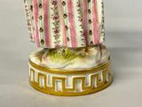 a figurine of a woman holding a fish in her hand