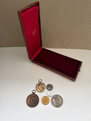 a small wooden box with a bunch of coins in it