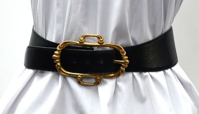 a black belt with a gold buckle on a mannequin mannequin