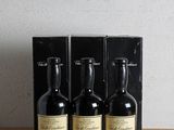 trois bouteilles de vin posées sur une table en bois