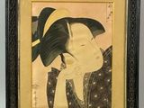 a framed picture of a woman with a hat on her head