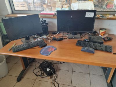 a desk with two computers and a keyboard on it
