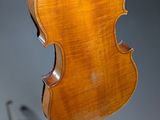an old violin hanging from a wall next to a clock