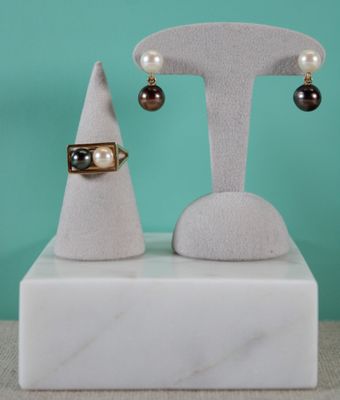 a pair of earrings and a ring on a stand on a table