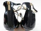 a pair of black high heeled shoes with zippers on them
