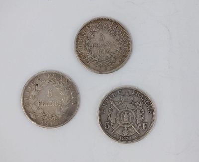 three silver coins sitting next to each other on a white surface