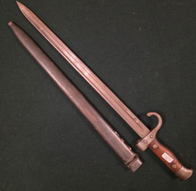 une vieille épée à la poignée en bois posée sur une surface noire