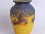 a yellow and blue vase sitting on a white surface