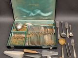 un coffret vert contenant de l'argenterie sur une table