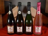 three bottles of sparkling wine are lined up on a table