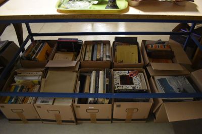 de nombreuses caisses de livres posées sur une table dans une pièce