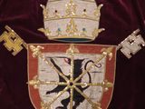 a red velvet jacket with a gold crown and keys on it