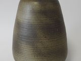 a brown vase that is sitting on a white surface