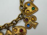 a close up of a gold bracelet with several charms on it