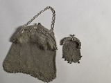 un vieux sac à main en maille argentée muni d'une chaîne et un petit sac à main argenté muni d'une chaîne