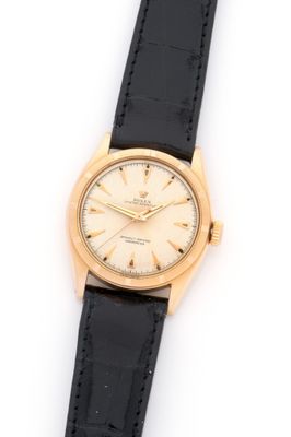 a close up of a watch on a black strap on a white surface