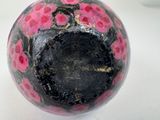 a black ball with pink flowers on it sitting on a table
